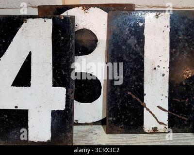 Detail of antique metal plates with numbers in white on a black background. Stock Photo