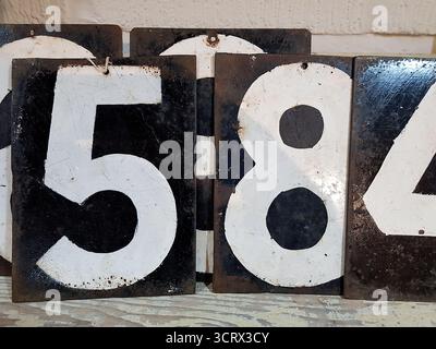 Detail of antique metal plates with numbers in white on a black background. Stock Photo