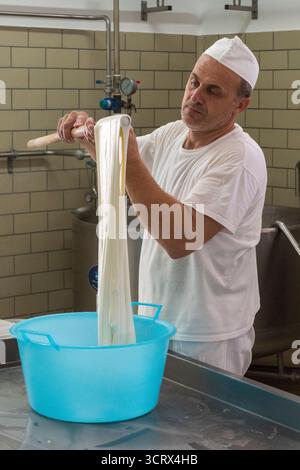 Making mozzarella cheese - the fresh curds are stretched and then moulded by hand into the familiar mozzarella shape (Sicily, Italy) Stock Photo