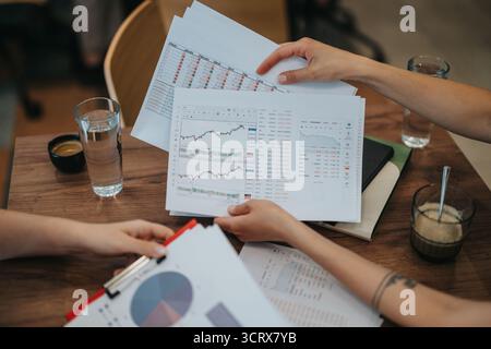 Business professionals analyzing financial charts and graphs in a meeting Stock Photo