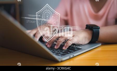 Child typing on laptop with smartwatch, overlay of shield and lock symbol representing cybersecurity, data protection, online privacy, internet safety Stock Photo