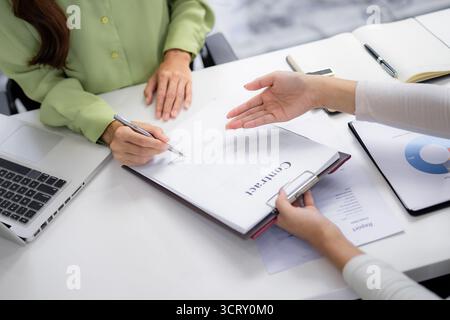 Professional partners finalize deal Two adult women collaborating on important legal document for partnership success Strategic business discussion le Stock Photo