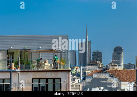 People on a roof terrace with the and the skyscrapers of Porta Nuova including UniCredit tower and Bosco Verticale ,Milan,Italy Stock Photo
