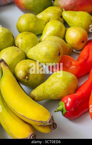 Advertising photography of fresh foods: spotless bananas, shiny pears, perfectly ripe avocados, clean potatoes, nectarines, and figs on a pastel blue Stock Photo