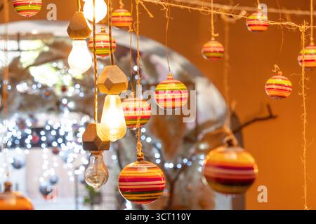 A string of colorful lights and ornaments hanging from the ceiling. The lights are of different colors and sizes, and the ornaments are also of variou Stock Photo