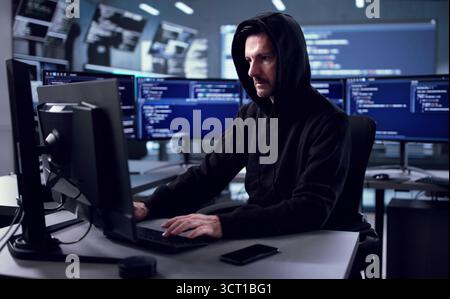 Male Caucasian Hacker Using Spy Software For Data Theft And Fraud. Possible Professions: Cybersecurity Technician Stock Photo