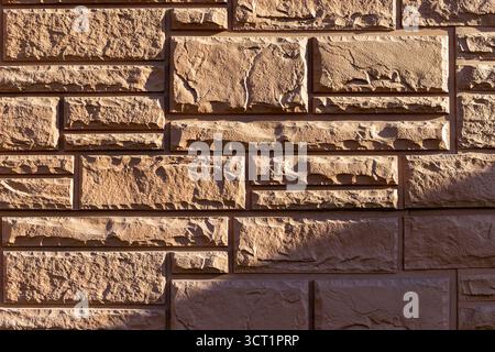 Close-up of a decorative stone brick wall with textured surface and natural patterns Stock Photo