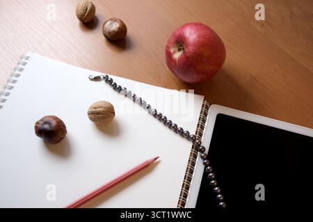 Writing tools and fruits arranged on a wooden table inspire creativity. Stock Photo