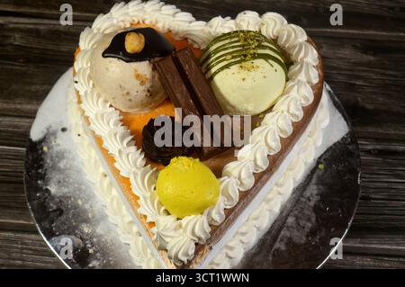 Ice cream cake of assorted and various flavors with a sponge cake layer within ice cream and whipped cream, Ice cream of mango, vanilla and chocolate, Stock Photo