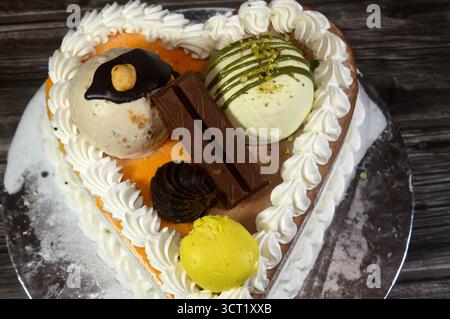 Ice cream cake of assorted and various flavors with a sponge cake layer within ice cream and whipped cream, Ice cream of mango, vanilla and chocolate, Stock Photo