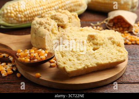 Freshly baked cornbread, cobs and seeds on wooden table, closeup Stock Photo