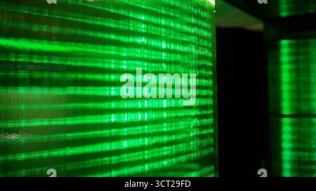Green glowing lines creating abstract patterns and digital code representing data transferring and cyber security concepts Stock Photo