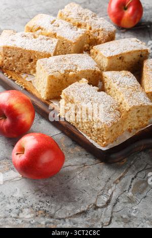 Applesauce cake is a dessert cake prepared using apple sauce, flour and sugar close-up on wooden board on a table. Vertical Stock Photo