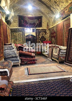 Traditional Persian carpet shop in Vakil Bazaar, Shiraz, Iran, displaying colorful handmade rugs and kilims. Stock Photo
