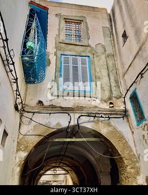 Street view in the old medina of Tunis, Tunisia. Ornate lamp post, vintage architecture, and shuttered balconies. Captured on 22 September 2025. Stock Photo