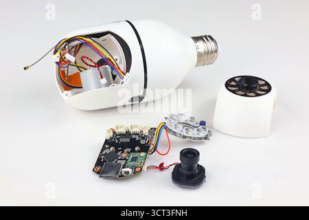 The image clearly shows each component of a smart light bulb camera, including the bulb housing, internal circuit board, camera module, and LED light Stock Photo