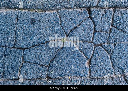 A damaged cracked paved road material Stock Photo