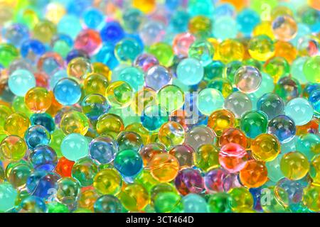 A bunch of colorful balls are scattered on a surface. The marbles are of various sizes and colors, creating a vibrant and lively scene. Concept of pla Stock Photo