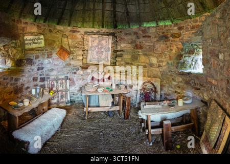 Ancient Rounded Stone Historic Scriptorium building, circular stone walls, thatched conical ...