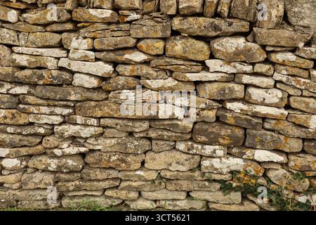 Dry stone wall construction with irregular rocks creating a natural texture, background, and aged surface. Cotswolds, England Stock Photo