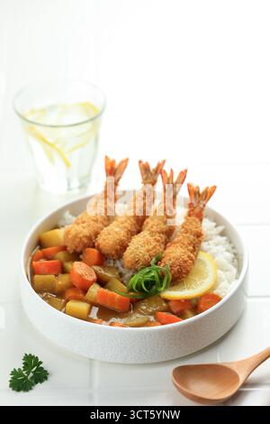 Japanese Curry Rice Topped with Shrimps Tempura in a Plate on White Background. Stock Photo