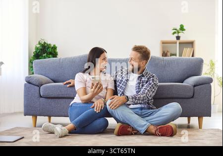 Happy family couple using a mobile phone and shopping in an online store together Stock Photo