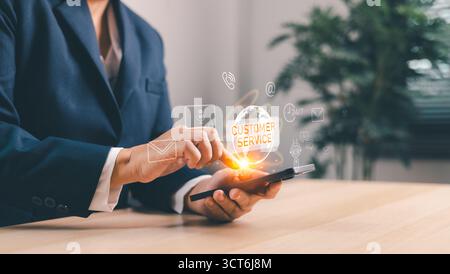 Business professional using smartphone with hologram customer service icon, futuristic digital support, online communication, AI technology, virtual a Stock Photo