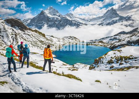 Small hiker group resting and enjoying the view near lake Bachalpsee, Grindelwald, Bernese Oberland, Switzerland, Europe Stock Photo
