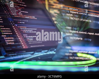 Highlighted code showing virus keyword overlaid on a developer screen, symbolizing malware, hacking, and cybersecurity vulnerability risks. Stock Photo