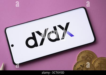 Dhaka, Bangladesh- 03 Oct 2025: Dydx logo on smartphone screen near Bitcoin coin and QR code on pink background Stock Photo