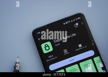 Dhaka, Bangladesh- 30 Sep 2025: On a blue surface, a smartphone displays the Trezor app with in the Google Play Store Stock Photo