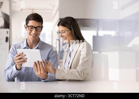 Happy young managers working on online project solution together Stock Photo