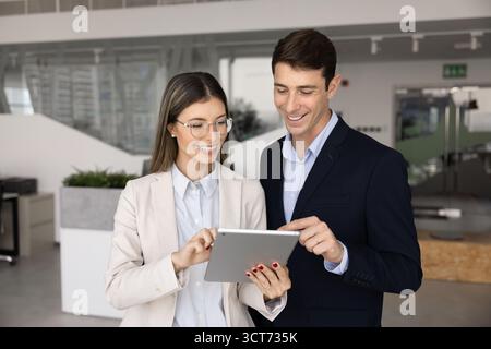 Two happy young Hispanic business partners working together Stock Photo
