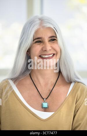 Happy senior Hispanic woman looking away, smiling Stock Photo