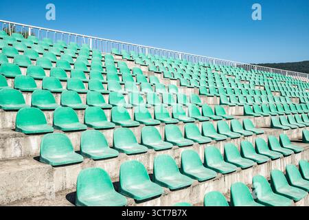 Green plastic stadium worn out chair seats in rows Stock Photo