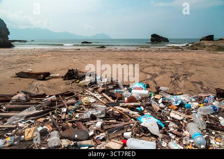 Large pile of washed-up plastic waste covering a sandy shore in Malaysia Stock Photo
