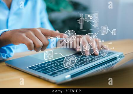 Engineer using laptop to control industrial automation system, digital factory management, smart manufacturing technology, and Industry 4.0 concept. Stock Photo