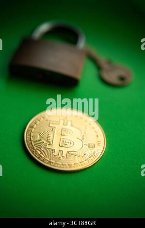Bitcoin coin with padlock on green background symbolizing security, privacy, and protection in cryptocurrency transactions Stock Photo