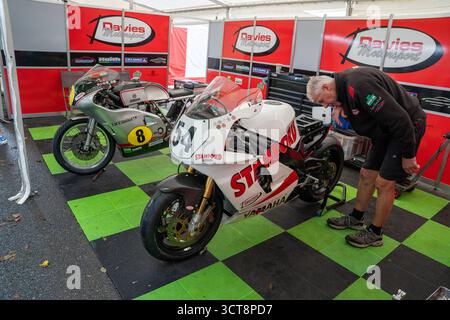Mechanic working on racing motorbikes in Davies Motorsport team garage at Isle of Man TT Stock Photo