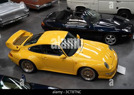 Classic yellow Porsche 911 sports car at indoor motor show display Stock Photo