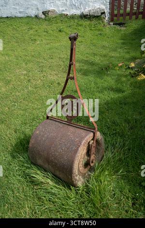 Vintage cast iron lawn roller on grass in traditional British garden Stock Photo