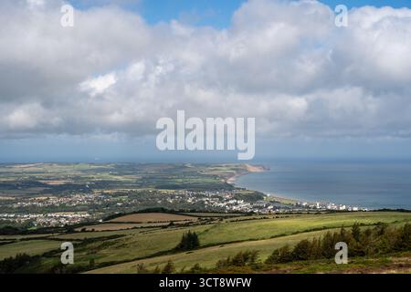 Panoramic view of Isle of Man coastline with rolling hills and seaside town Stock Photo