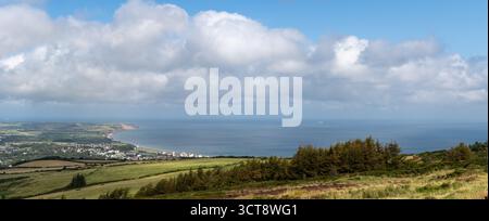 Panoramic view across Isle of Man countryside to coastline and Irish Sea under dramatic cloudy sky Stock Photo