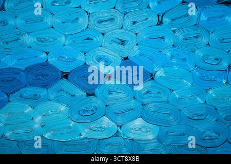 New blue plastic bags are rolled and stacked on top of each other Stock Photo