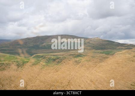 Rolling hills and moorland landscape under cloudy sky in Northumberland countryside Stock Photo