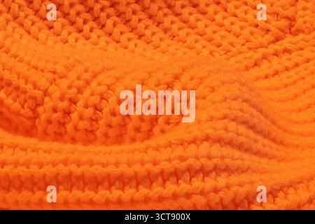 A close up of a knitted orange sweater. The sweater is orange and has a fuzzy texture Stock Photo