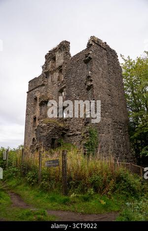 Ancient ruined castle tower with moss-covered stone walls and wooden fence in Scottish countryside Stock Photo