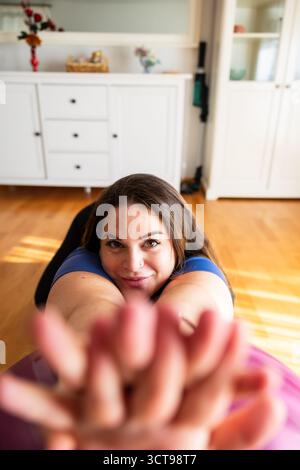Pregnant woman smiling and reaching forward during fitness ball stretch. Lifestyle. Pregnancy. Stock Photo