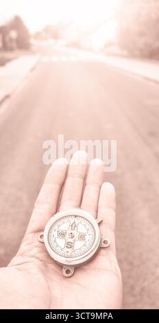 A compass in hand, conceptual photo, selective focus, color toning applied. Stock Photo