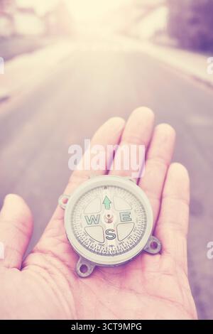 A compass in hand, conceptual photo, selective focus, color toning applied. Stock Photo